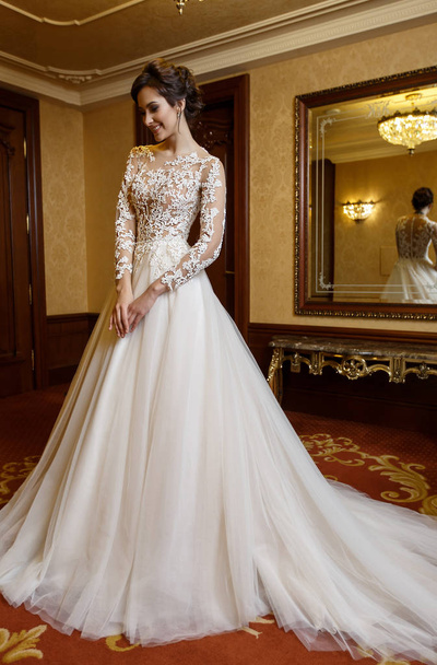 Pretty woman in luxury bridal dress indoor with lace - Фото, зображення