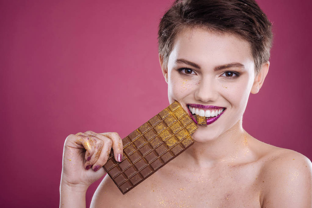 Positive beautiufl woman holdign chocolate bar - Photo, Image