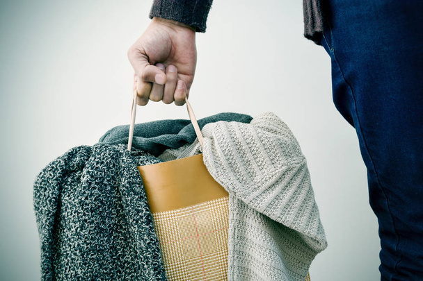 homem com um saco de compras com roupas
 - Foto, Imagem