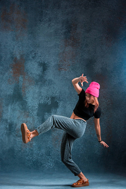 Young girl break dancing on wall background. - Fotó, kép
