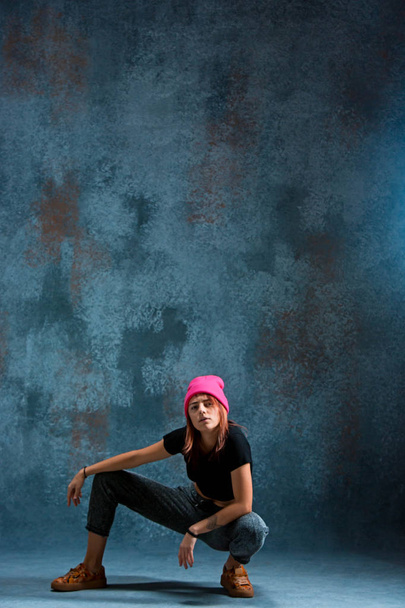 Young girl break dancing on wall background. - Valokuva, kuva