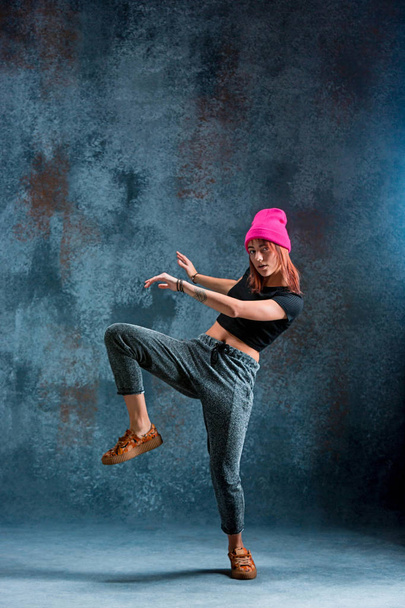 Young girl break dancing on wall background. - Photo, Image