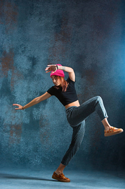Young girl break dancing on wall background. - Foto, Imagen