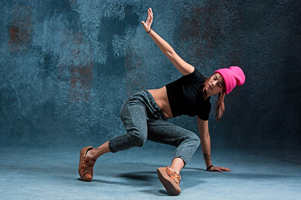 Young girl break dancing on wall background. - Foto, imagen