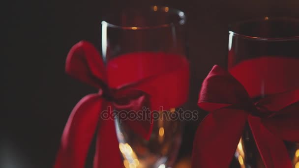two glasses of champagne with red ribbon. The 14th of February. - Filmmaterial, Video