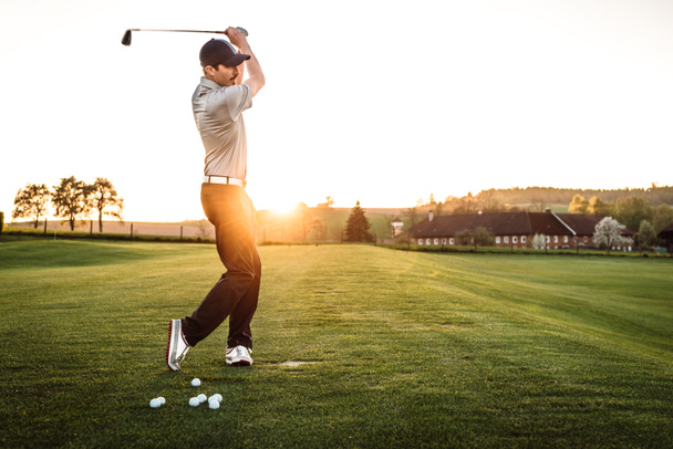Nuori mies heilumassa golfkentällä
 - Valokuva, kuva