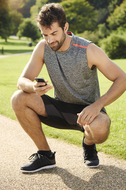 Athletic man using smartphone - Фото, зображення