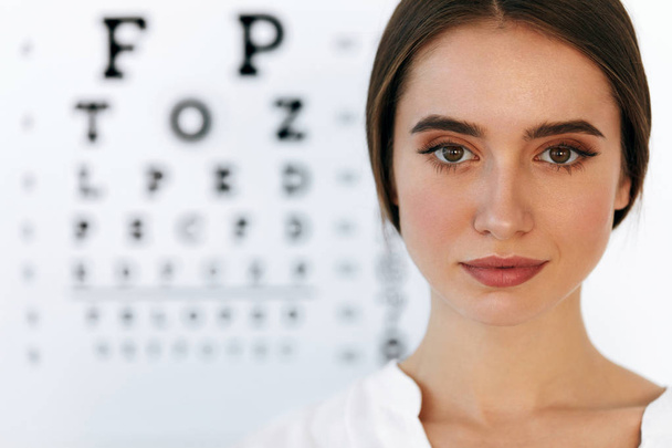 Beautiful Woman With Eye Test Chart At Ophthalmology Office - Foto, imagen
