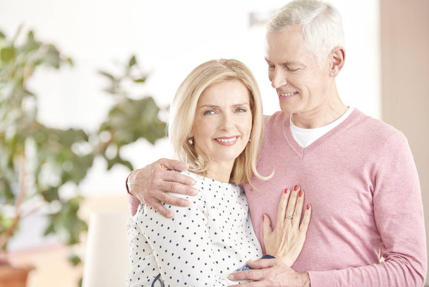 happy senior couple standing together at home - Foto, Imagen