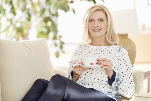 smiling woman drinking tea at home - Fotografie, Obrázek