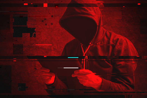 Cyber attack with unrecognizable hooded hacker using tablet comp - Фото, изображение