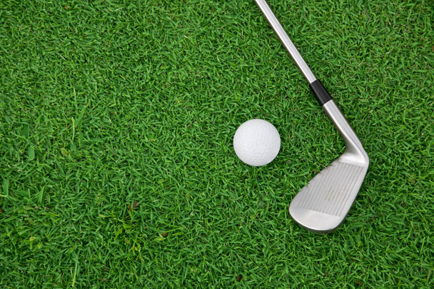 demir golf kulübü ve top yeşil çimenlerin üzerinde - Fotoğraf, Görsel