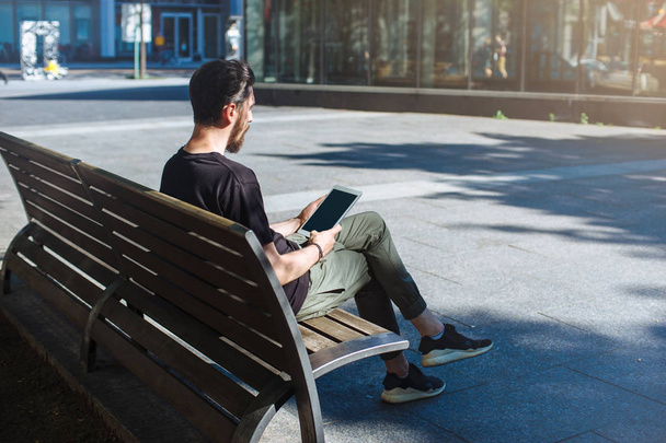 Hipster-Mann nutzt modernes digitales Tablet im Freien. - Foto, Bild