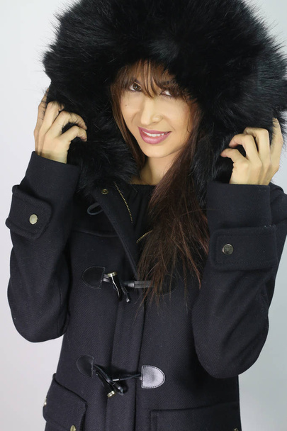 Divatos nő visel kabátot prémes kapucnival - Fotó, kép