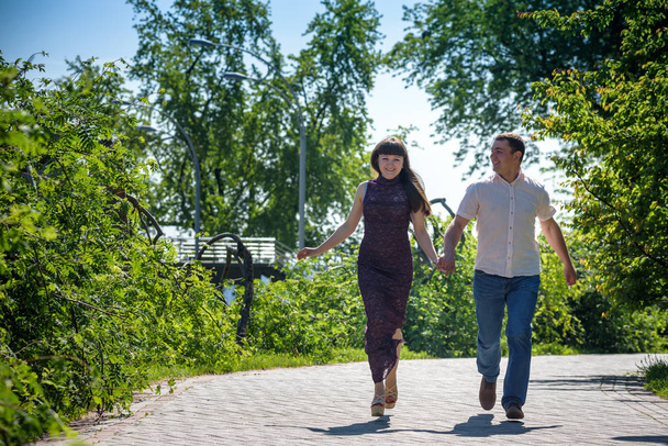 愛する若いカップルは夏に公園を歩く. - 写真・画像