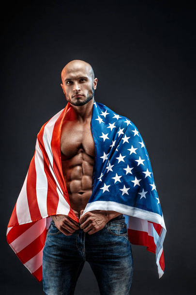 Portrait of bald strong bodybuilder in American flag in studio. Isolated. - Valokuva, kuva