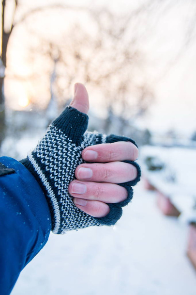 Mano masculina mostrando pulgares arriba en guantes de invierno
 - Foto, imagen
