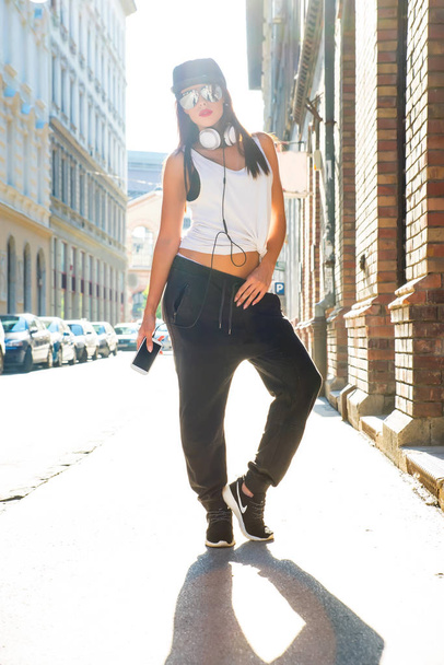 Хип-хоп девушка с наушниками в городской среде - Фото, изображение