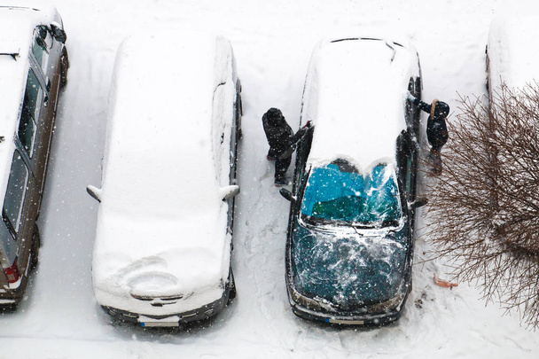 Χειμώνα έρχονται στην πόλη και οι άνθρωποι ξεκινήσετε καθαρό αυτοκίνητο - Φωτογραφία, εικόνα