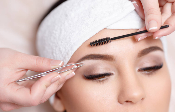 Beautiful young woman gets eyebrow correction procedure - Foto, Imagem