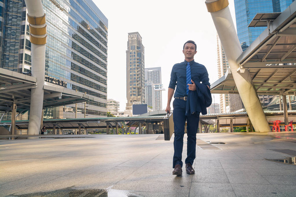 Giovane bell'uomo d'affari che cammina all'aperto nella città moderna
 - Foto, immagini