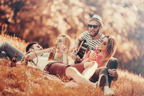 Happy young friends having picnic in the park - Photo, Image