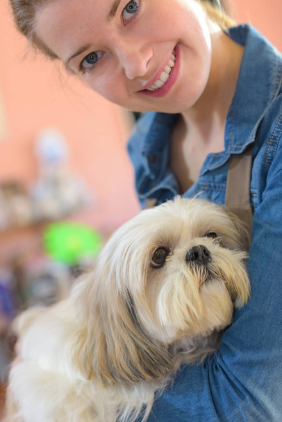 portrait of young woman and her dog in pet store - Fotó, kép