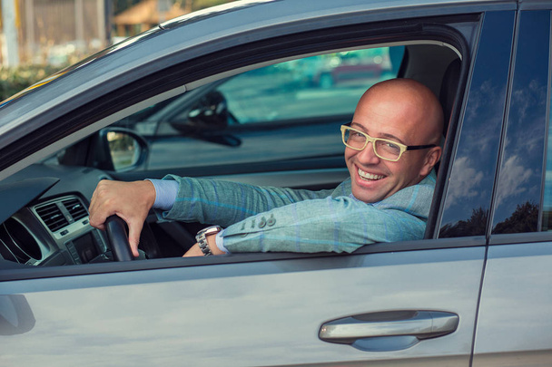 Pohledný muž úsměv na tváři, sedět v autě, ruce na volantu. Instagram efekt filtru  - Fotografie, Obrázek