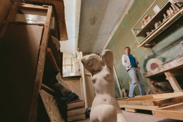 statue of a naked girl. Factory for Production  plaster molds. cluttered dusty old warehouse at night - Fotografie, Obrázek