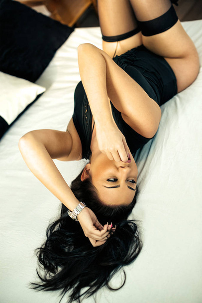 Ξαπλωμένος στο κρεβάτι του ξενοδοχείου φορώντας σέξι ρούχα - Φωτογραφία, εικόνα