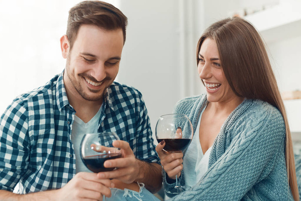 Крупним планом молода пара насолоджується вином вдома
 - Фото, зображення
