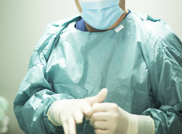 Chirurg si nasazuje rukavice - Fotografie, Obrázek