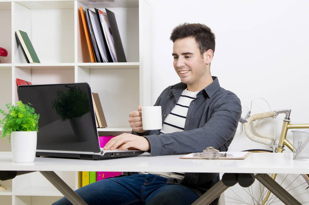 Mies työskentelee kannettavan tietokoneen kanssa
 - Valokuva, kuva