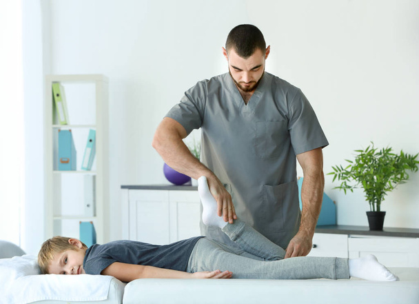 Physiotherapist working with patient in clinic - Фото, зображення