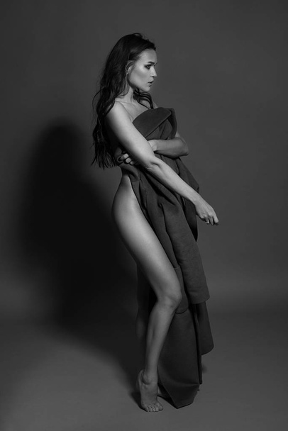 Black and white photo of a seductive brunette girl in studio. Sexy topless woman. Monochrome image. - Fotó, kép