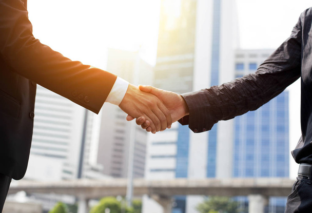 Business agreement hand shaking in front of modern building  - Photo, Image