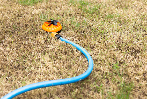 Orange zraszacze w suchej trawy  - Zdjęcie, obraz