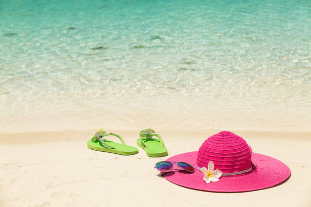 Duża plaża różowy kapelusz, okulary słoneczne i zielony kapcie w golde - Zdjęcie, obraz