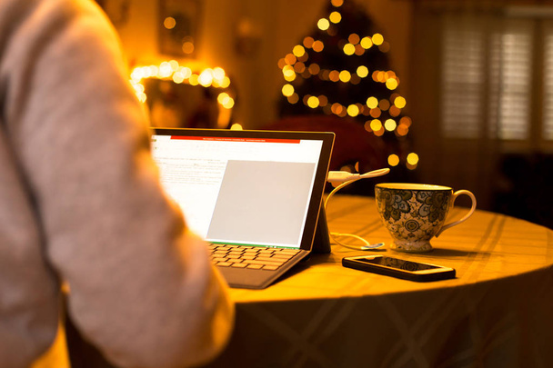 Бізнес-леді, що друкує на ноутбуці, працює вдома на різдвяний час
 - Фото, зображення