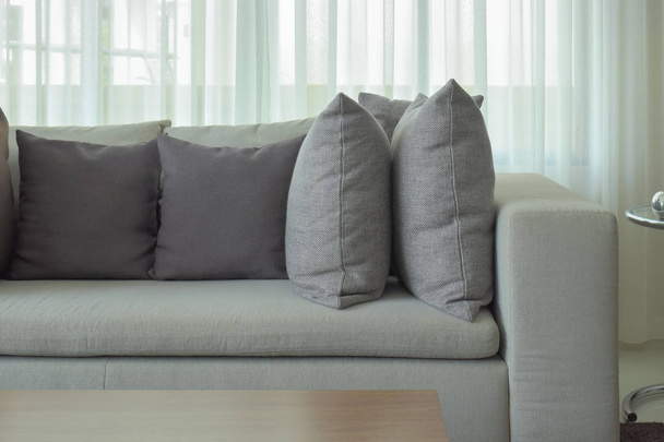 Gray pillows on beige color sofa with sheer in background - Zdjęcie, obraz