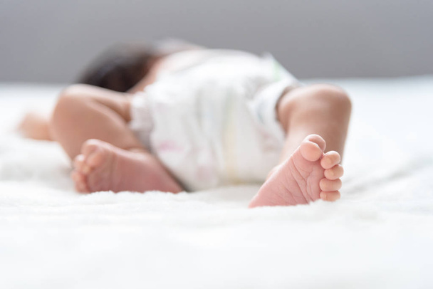 生まれたばかりの赤ちゃんの足ベッドの上 - 写真・画像