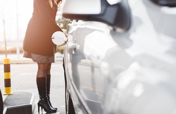 Mujer repostando coche con diesel
 - Foto, imagen
