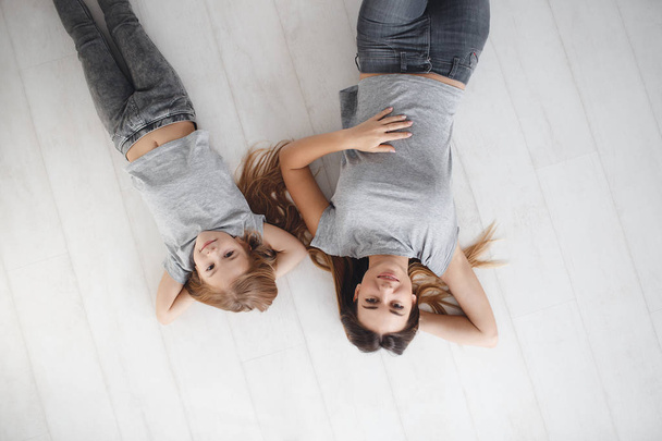 Mum and daughter lie on the floor on his back - Foto, Imagem