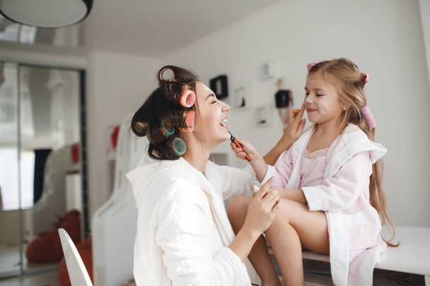 Mother and daughter doing hair and makeup together - Foto, Bild