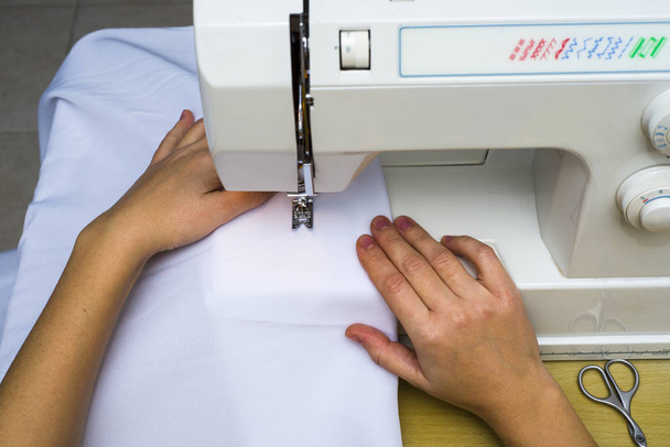 Женские руки работают над швейной машинкой. Черное и белое
. - Фото, изображение