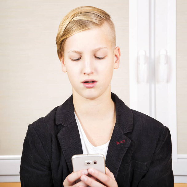 Adolescente con teléfono en las manos
 - Foto, Imagen