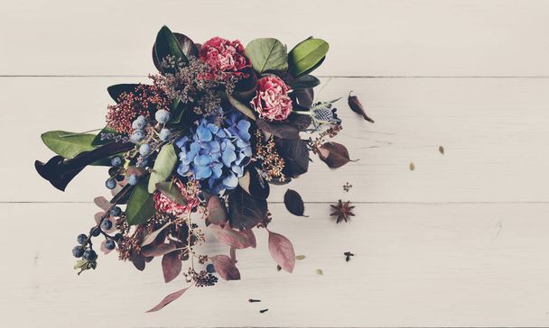 Beautiful bouquet floral composition of dried meadow flowers and leaves - Фото, изображение