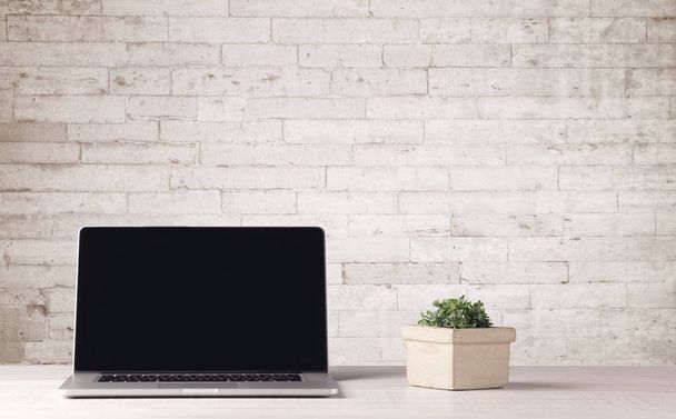 Business laptop with white brick wall - Fotó, kép