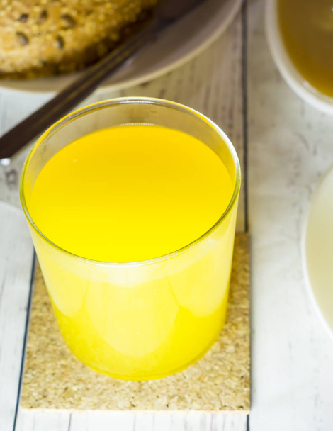 Healthy orange juice on a white wooden table - Фото, изображение