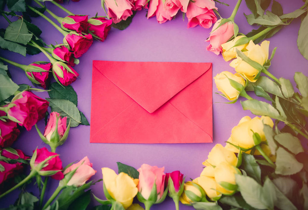 roze bloemen en envelop  - Foto, afbeelding